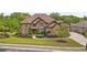 Expansive brick home with manicured lawn, mature trees and a winding driveway at 580 Grimsby Ct, Suwanee, GA 30024