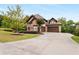 Beautiful home with a well-manicured lawn, mature trees, and a long driveway leading to a three-car garage at 580 Grimsby Ct, Suwanee, GA 30024