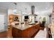 Open kitchen featuring gas range, granite countertop island with seating, and a view to an adjacent living room at 580 Grimsby Ct, Suwanee, GA 30024