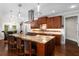 Well-lit kitchen boasts dark wood cabinets, stainless appliances, and a central island for cooking and dining at 580 Grimsby Ct, Suwanee, GA 30024