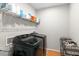 Well-organized laundry area featuring a modern washer and dryer, shelving, and storage baskets at 580 Grimsby Ct, Suwanee, GA 30024
