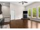Open living room with a fireplace, dark hardwood floors, and lots of natural light at 580 Grimsby Ct, Suwanee, GA 30024