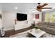 Living room with hardwood floors, a large TV, and a comfortable seating area at 580 Grimsby Ct, Suwanee, GA 30024