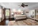 Bright main bedroom featuring natural light, tray ceilings, dark wood floors and ensuite bath access at 580 Grimsby Ct, Suwanee, GA 30024