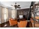 Cozy office with ample natural light, a ceiling fan, dark wood floors, and comfortable seating at 580 Grimsby Ct, Suwanee, GA 30024