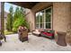 Covered brick patio with comfortable seating, ideal for outdoor relaxation and entertaining with gas grill and space heater at 580 Grimsby Ct, Suwanee, GA 30024