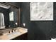 Powder room featuring distinctive wallpaper, framed mirror, granite countertops, and pedestal sink at 580 Grimsby Ct, Suwanee, GA 30024