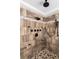Walk-in shower with multiple shower heads, stone floors and decorative tile at 580 Grimsby Ct, Suwanee, GA 30024