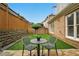 Charming backyard featuring artificial turf, a stone retaining wall, and a table and chairs for outdoor enjoyment at 6355 Glen Oaks Ln, Atlanta, GA 30328