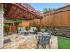 Inviting stone patio with stylish seating and a pergola strung with lights, perfect for outdoor entertaining at 6355 Glen Oaks Ln, Atlanta, GA 30328