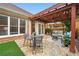 Cozy backyard patio with a stone surface, comfortable seating under a pergola, and lush green artificial turf at 6355 Glen Oaks Ln, Atlanta, GA 30328