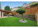 Spacious backyard featuring artificial turf, a stone retaining wall, and a cozy patio with a pergola at 6355 Glen Oaks Ln, Atlanta, GA 30328