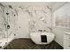 Spa-like bathroom with freestanding tub, walk-in shower, herringbone floors, and marble accent wall at 6355 Glen Oaks Ln, Atlanta, GA 30328