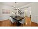 Dining room boasts a modern chandelier and hardwood flooring, adjacent to an open staircase at 6355 Glen Oaks Ln, Atlanta, GA 30328