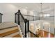 Bright foyer with hardwood floors, black iron railing, and a stylish light fixture creating a welcoming entrance at 6355 Glen Oaks Ln, Atlanta, GA 30328