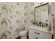 Charming half bathroom with patterned wallpaper, contemporary vanity, and stylish mirror at 6355 Glen Oaks Ln, Atlanta, GA 30328