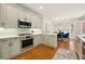 Bright kitchen with stainless steel appliances, quartz countertops, and adjoining breakfast nook at 6355 Glen Oaks Ln, Atlanta, GA 30328