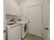 Functional laundry room featuring modern washer and dryer, complemented by patterned tile floor at 6355 Glen Oaks Ln, Atlanta, GA 30328