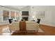 Cozy living room featuring hardwood floors, a stone fireplace, and large windows at 6355 Glen Oaks Ln, Atlanta, GA 30328