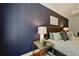 Main bedroom featuring a navy accent wall with a luxurious upholstered headboard and lighting at 6355 Glen Oaks Ln, Atlanta, GA 30328