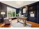 Stylish home office with dark blue built-in shelving, a modern desk, and a comfortable seating area at 6355 Glen Oaks Ln, Atlanta, GA 30328