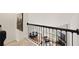 Upstairs hallway featuring iron railing overlooking downstairs living area with hardwood floors and fireplace at 6355 Glen Oaks Ln, Atlanta, GA 30328