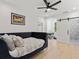 Bright bedroom featuring hardwood floors, ceiling fan, modern light fixture, and a barn door to the bathroom at 650 Jones Rd, Roswell, GA 30075