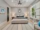 Cozy bedroom with a tufted headboard, patterned rug, and soft natural light from large windows at 650 Jones Rd, Roswell, GA 30075