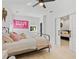 Bright bedroom with hardwood floors, ceiling fan, and a view to an adjacent bedroom through white sliding doors at 650 Jones Rd, Roswell, GA 30075