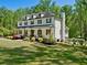 Beautifully landscaped yard surrounding this two-story home with a covered front porch and a glimpse of a backyard pool at 650 Jones Rd, Roswell, GA 30075
