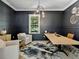 Sophisticated home office featuring dark walls, wainscoting, a modern light fixture, and a large work table at 650 Jones Rd, Roswell, GA 30075