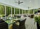 Relaxing screened porch with comfortable seating, ceiling fans, and views of a lush, wooded backyard setting at 650 Jones Rd, Roswell, GA 30075