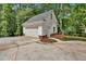 Detached garage featuring white doors, siding, and decorative stone accents surrounded by lush landscaping at 11 Headden Nw Rdg, Cartersville, GA 30121