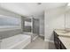 Bathroom featuring a soaking tub, glass-enclosed shower, and double vanity at 3750 Thackary Dr, Powder Springs, GA 30127