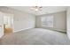 Spacious bedroom featuring neutral walls, soft carpet, ceiling fan, and natural light from the double window at 3750 Thackary Dr, Powder Springs, GA 30127