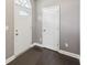 A well-lit foyer features dark hardwood floors, neutral walls, and a white door with glass accents at 3750 Thackary Dr, Powder Springs, GA 30127