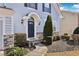 Close-up of a front door with stone accents, a curved walkway, and manicured shrubs in front of the house at 3750 Thackary Dr, Powder Springs, GA 30127