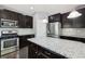 Kitchen features dark cabinets, granite countertops, stainless steel appliances, and an island at 3750 Thackary Dr, Powder Springs, GA 30127