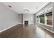 Bright living room boasts dark wood floors, fireplace, and lots of windows offering natural light at 3750 Thackary Dr, Powder Springs, GA 30127