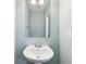 Powder room with pedestal sink, mirror, and light blue paint at 3750 Thackary Dr, Powder Springs, GA 30127