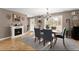 Formal dining room with hardwood floors, a decorative chandelier, and a cozy fireplace at 6045 Mockingbird Rd, Cumming, GA 30028