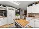Spacious kitchen with white cabinets, a butcher block island, and a breakfast nook at 6045 Mockingbird Rd, Cumming, GA 30028