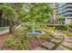 Serene fountain surrounded by lush greenery and a stone pathway, creating a tranquil outdoor space at 700 Park Regency Ne Pl # 1407, Atlanta, GA 30326