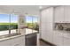 Sleek kitchen with white cabinets, stainless steel appliances, granite countertops, and scenic views from the adjacent living area at 700 Park Regency Ne Pl # 1407, Atlanta, GA 30326