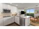 Modern kitchen with white cabinetry, stainless steel appliances, and an open layout leading to a living area with scenic views at 700 Park Regency Ne Pl # 1407, Atlanta, GA 30326