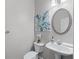 Half-bath including an oval mirror, pedestal sink, and decorative floral artwork at 2155 Mindy Ln, Cumming, GA 30041