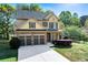 Charming two-story home featuring a two-car garage, manicured lawn, and beautiful stone and siding accents at 2155 Mindy Ln, Cumming, GA 30041