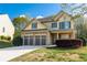 Charming two-story home featuring a two-car garage, manicured lawn, and beautiful stone and siding accents at 2155 Mindy Ln, Cumming, GA 30041
