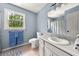Bright bathroom featuring a vanity with sink, tile flooring, and a window view of lush greenery at 411 Hollis Cir, Dallas, GA 30157