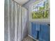 Bathroom with blue accents, shower curtain, towel rack and window showcasing a wooded view at 411 Hollis Cir, Dallas, GA 30157